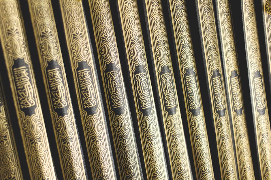 Deskripsi gambar dalam Bahasa Indonesia: Foto sebuah naskah klasik kitab kuning yang terbuka di atas meja kayu tua dengan pencahayaan hangat, di sampingnya terdapat pena bulu dan tinta, menciptakan suasana keilmuan Islam yang mendalam dan tradisional.