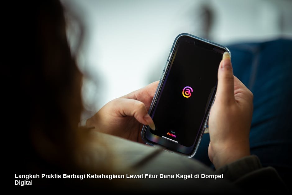 Seseorang sedang memegang ponsel pintar yang menampilkan antarmuka aplikasi dompet digital dengan notifikasi keberhasilan pengiriman saldo.