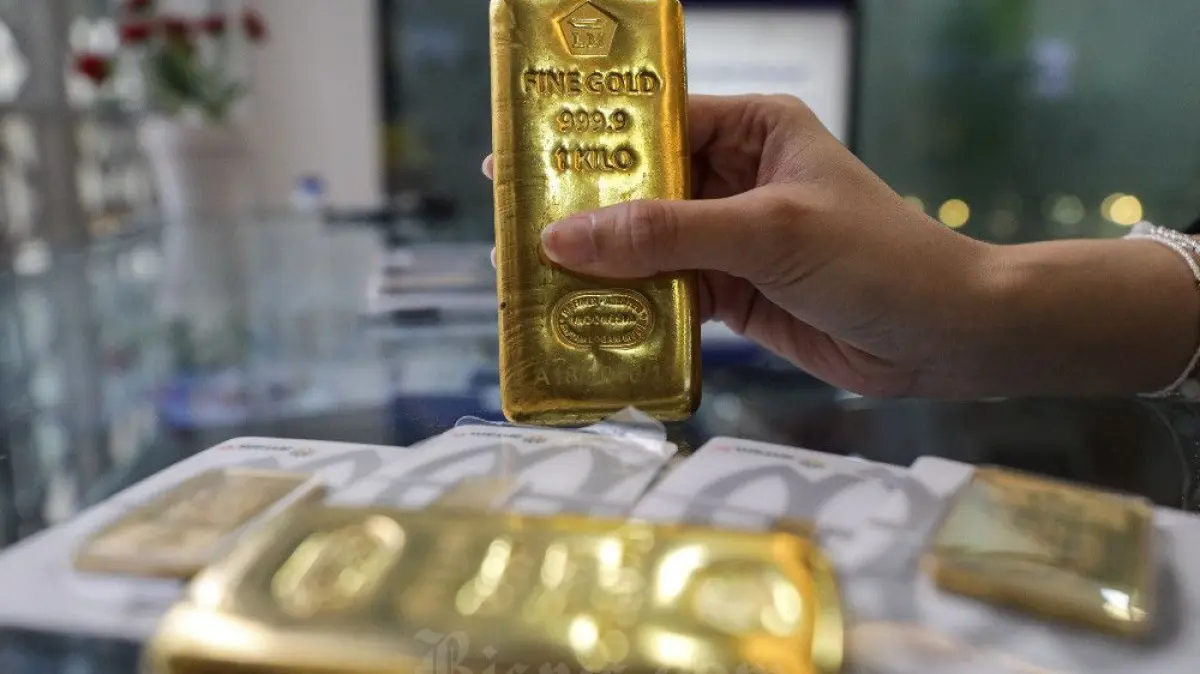 Karyawati memperlihatkan kepingan emas Antam di Jakarta, Senin (30/6/2025). Bisnis/Arief Hermawan P