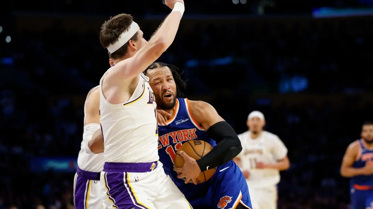 Guard New York Knicks Jalen Brunson (11) menabrak guard Los Angeles Lakers Austin Reaves (15) saat membawa bola pada babak kedua pertandingan bola basket NBA, Minggu, 8 Maret 2026, di Los Angeles. (AP Photo/Caroline Brehman)