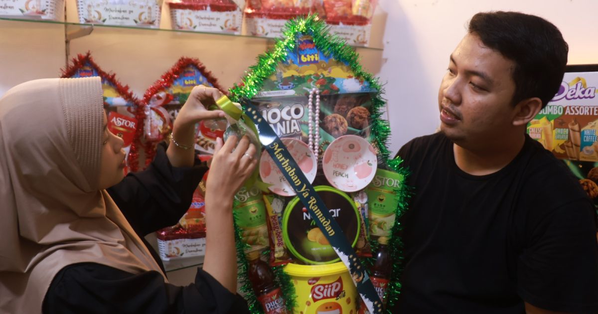 Pasangan suami istri Rizky dan Nur Aida saat merapihkan parcel lebaran jualannya. Foto : bogorplus.id