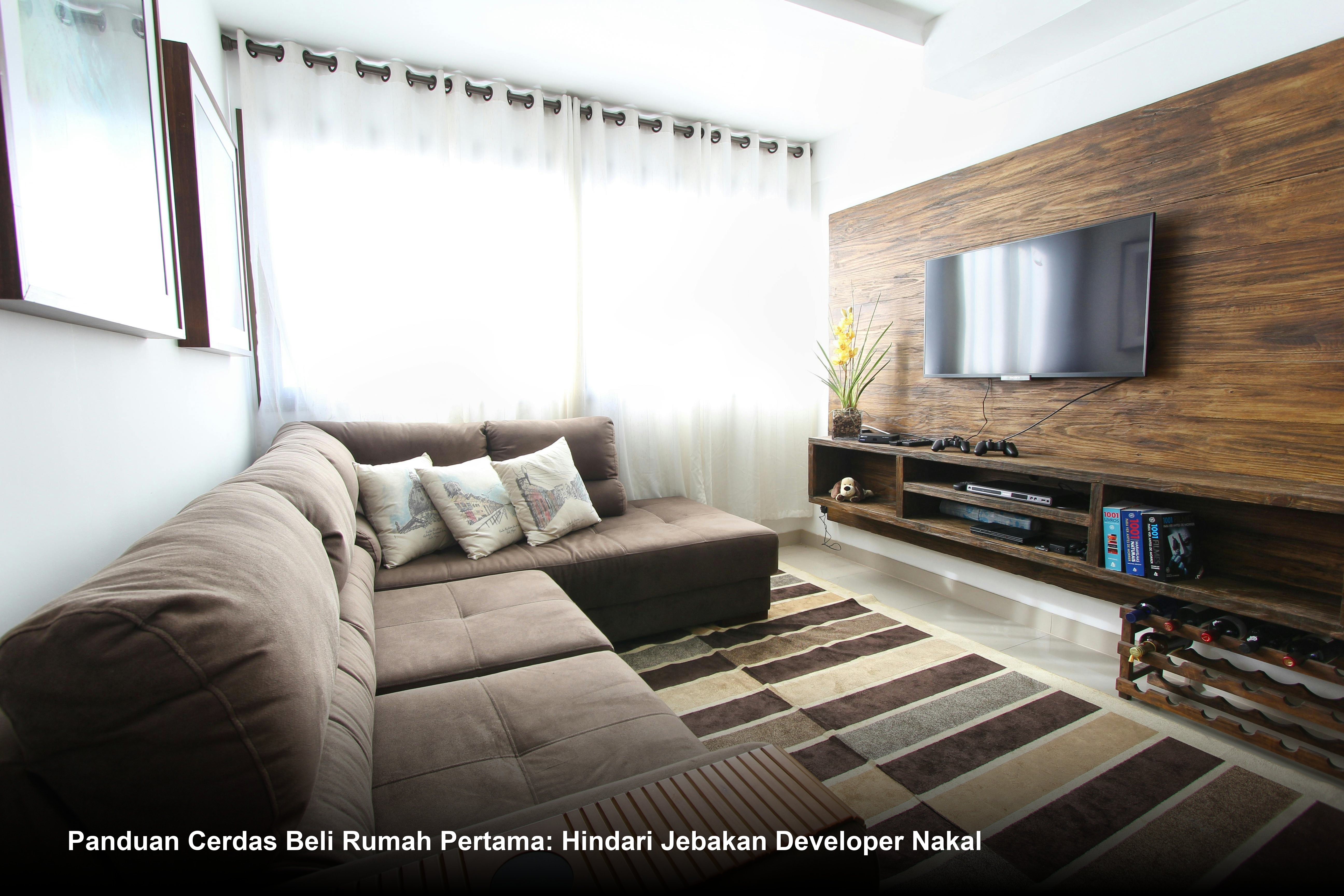 Seorang pasangan muda sedang melakukan penandatanganan dokumen akad kredit KPR Bank di hadapan notaris dengan latar belakang maket rumah minimalis modern.